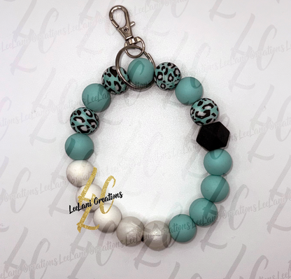 Handmade teal leopard print beaded wristlet keychain with black hexagon focal bead and silver lobster claw clasp