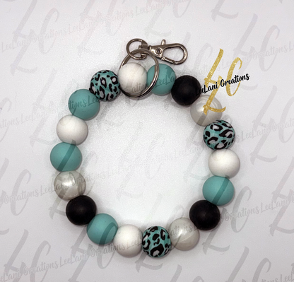 Handmade teal leopard print beaded wristlet keychain with black, white and pearl gray round silicone beads and silver clasp