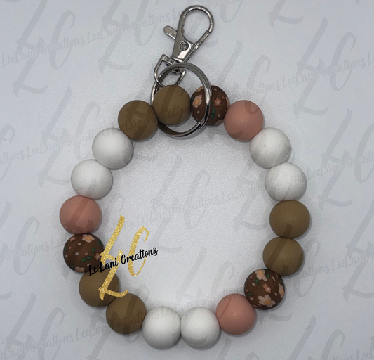 Handmade earthy floral beaded wristlet keychain with brown floral print, olive green, blush pink and white silicone beads and silver lobster claw clasp